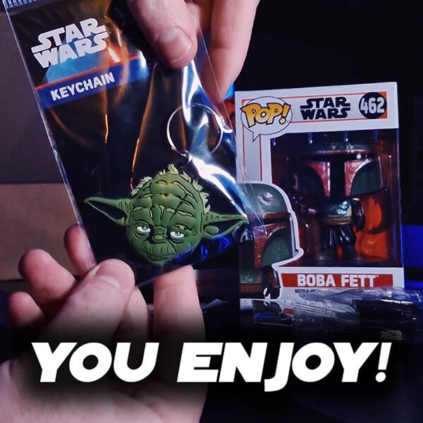 Keychain of Yoda from Star Wars held by a hand, with Boba Fett Pop! vinyl figure in the background.
